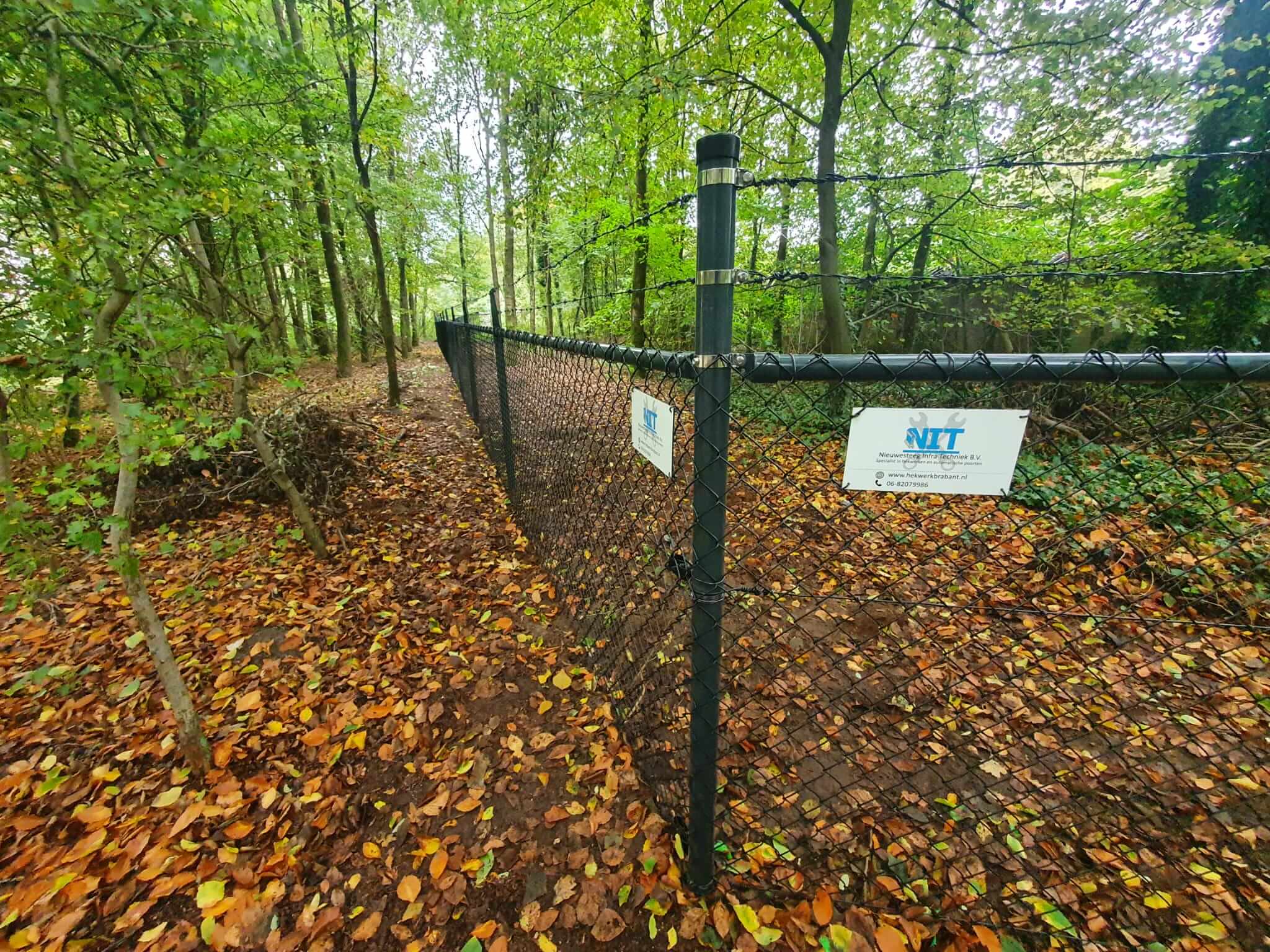 Gaashekwerk langs groen terrein met hoogteverschillen