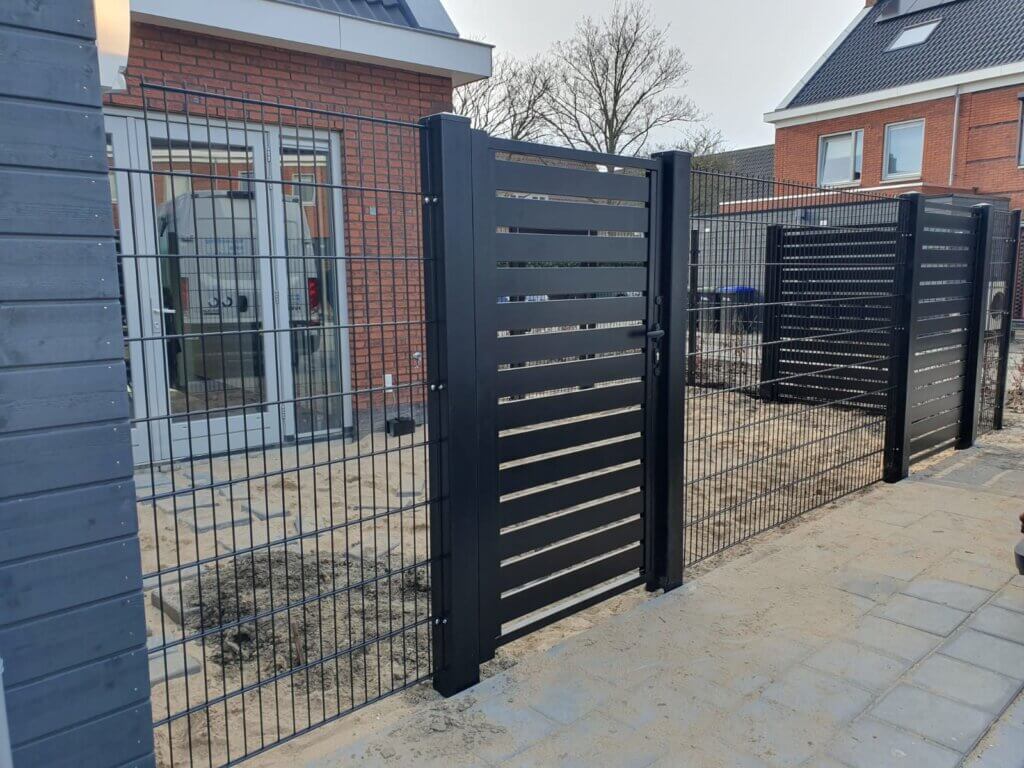 Zwart sierhekwerk Malachite met horizontale lamellen, gecombineerd met dubbelstaafmathekwerk, geplaatst bij een nieuwbouwwoning in Dordrecht.