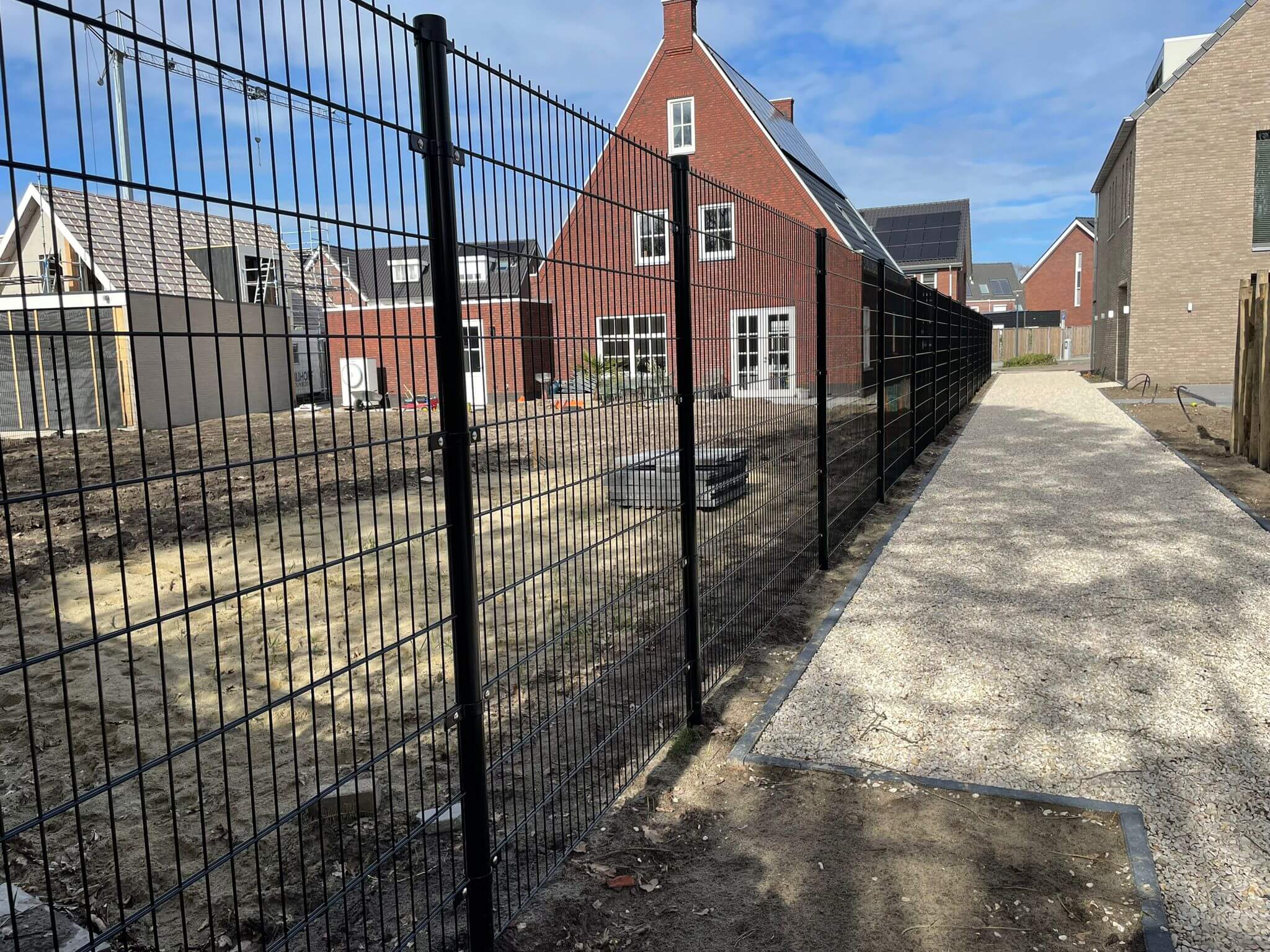 Detail van zwart dubbelstaafmat hekwerk langs groen terrein
