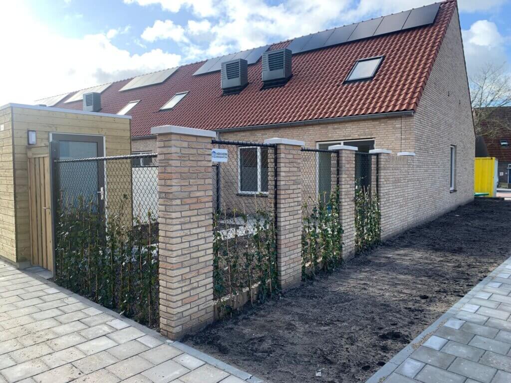 Gaashekwerk met houten poort en beplanting in nieuwbouwwijk