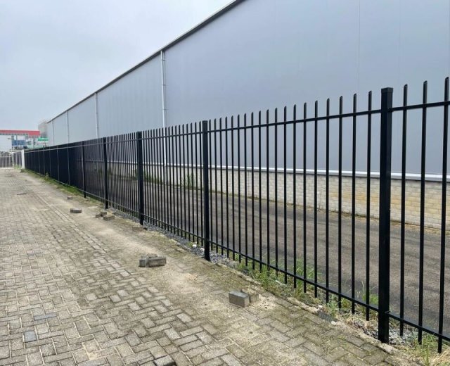 Spijlenhekwerk in zwarte coating geplaatst rondom een bedrijfsterrein in Raamsdonksveer.