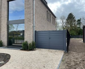 Moderne tuinafsluiting van antraciet metaal bij een eigentijdse woning, geplaatst door Hekwerk Brabant