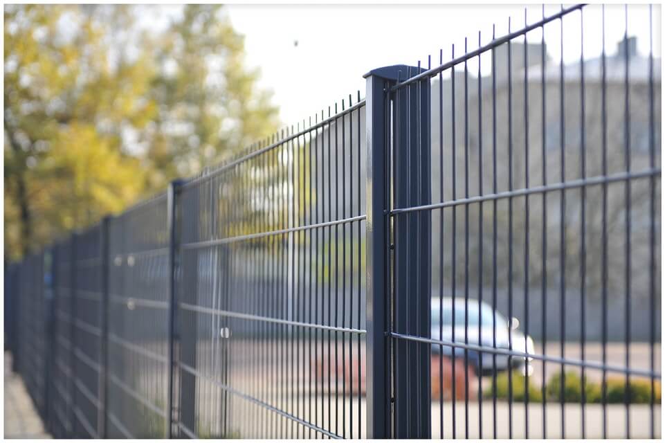 Stevig geplaatst dubbelstaafmat hekwerk langs een oprit, professioneel gemonteerd voor optimale veiligheid en afbakening.